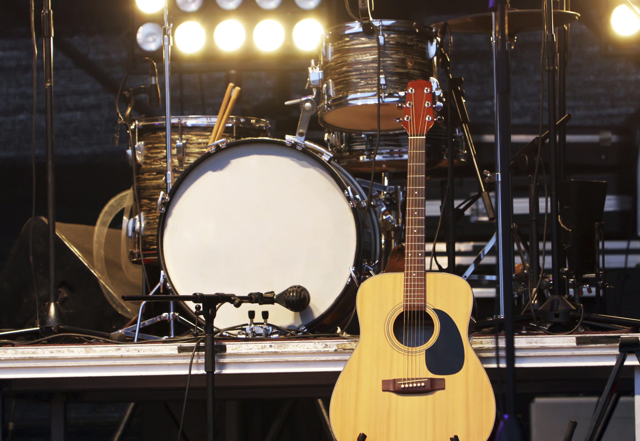 Concert stage with guitar and drum set.