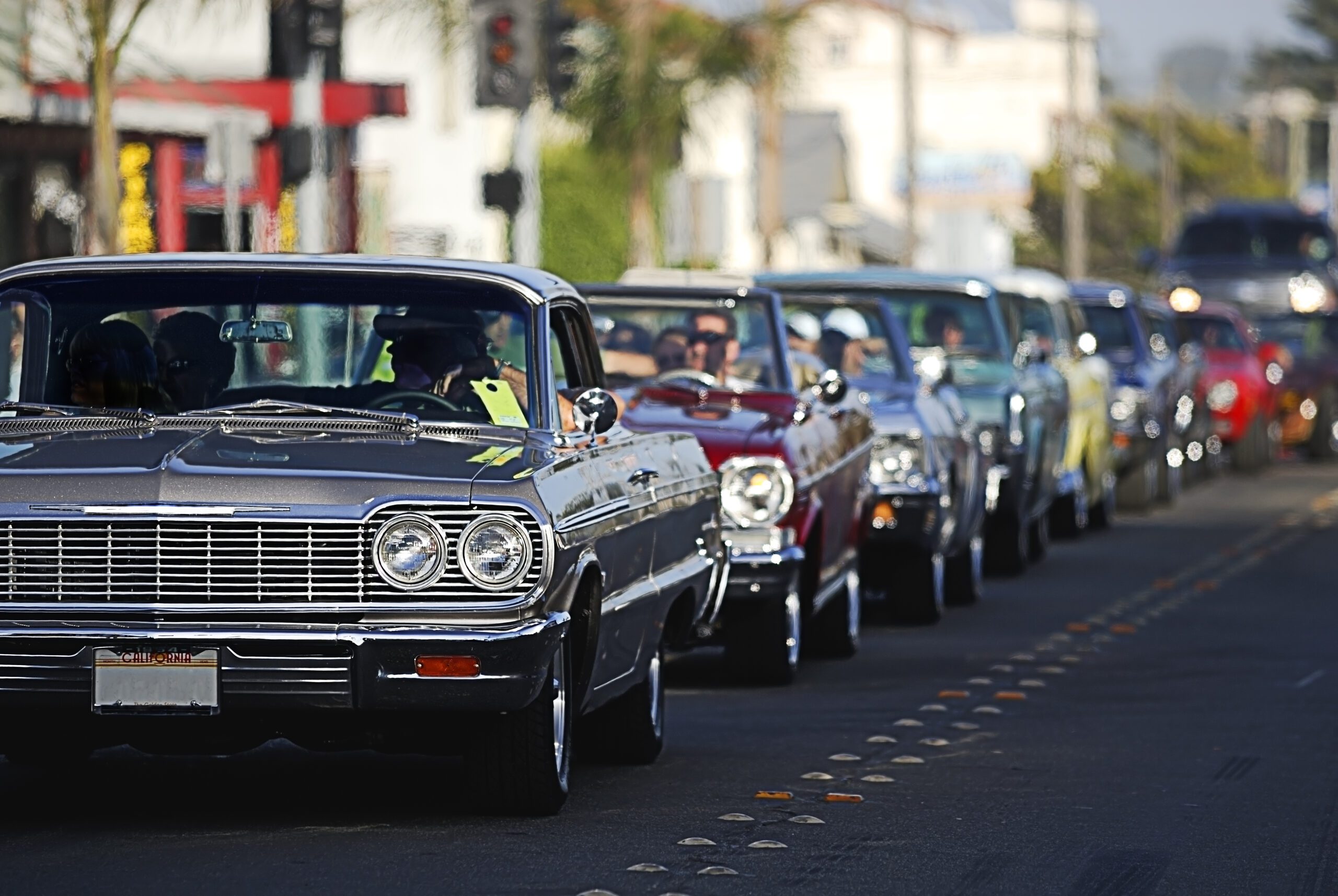 A line up of classic old cars cruising the local strip.