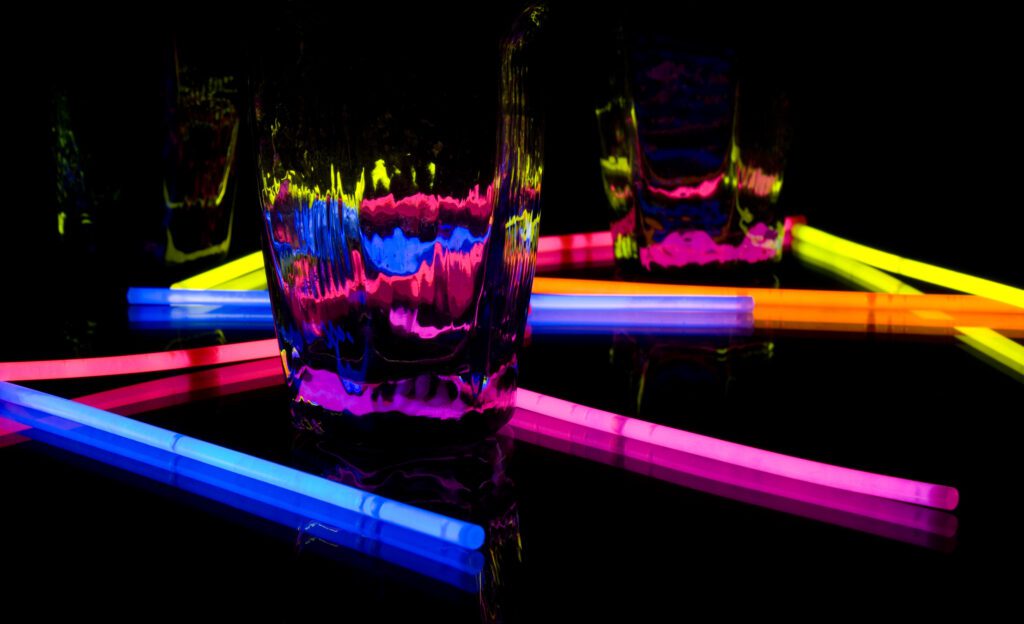 Dark scenery, glow sticks (multiple colors) in water.