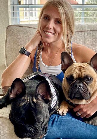 Young adult woman with two Frenchie dogs