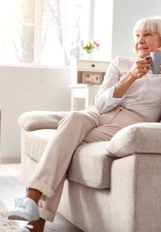 Senior woman drinking coffee at couch